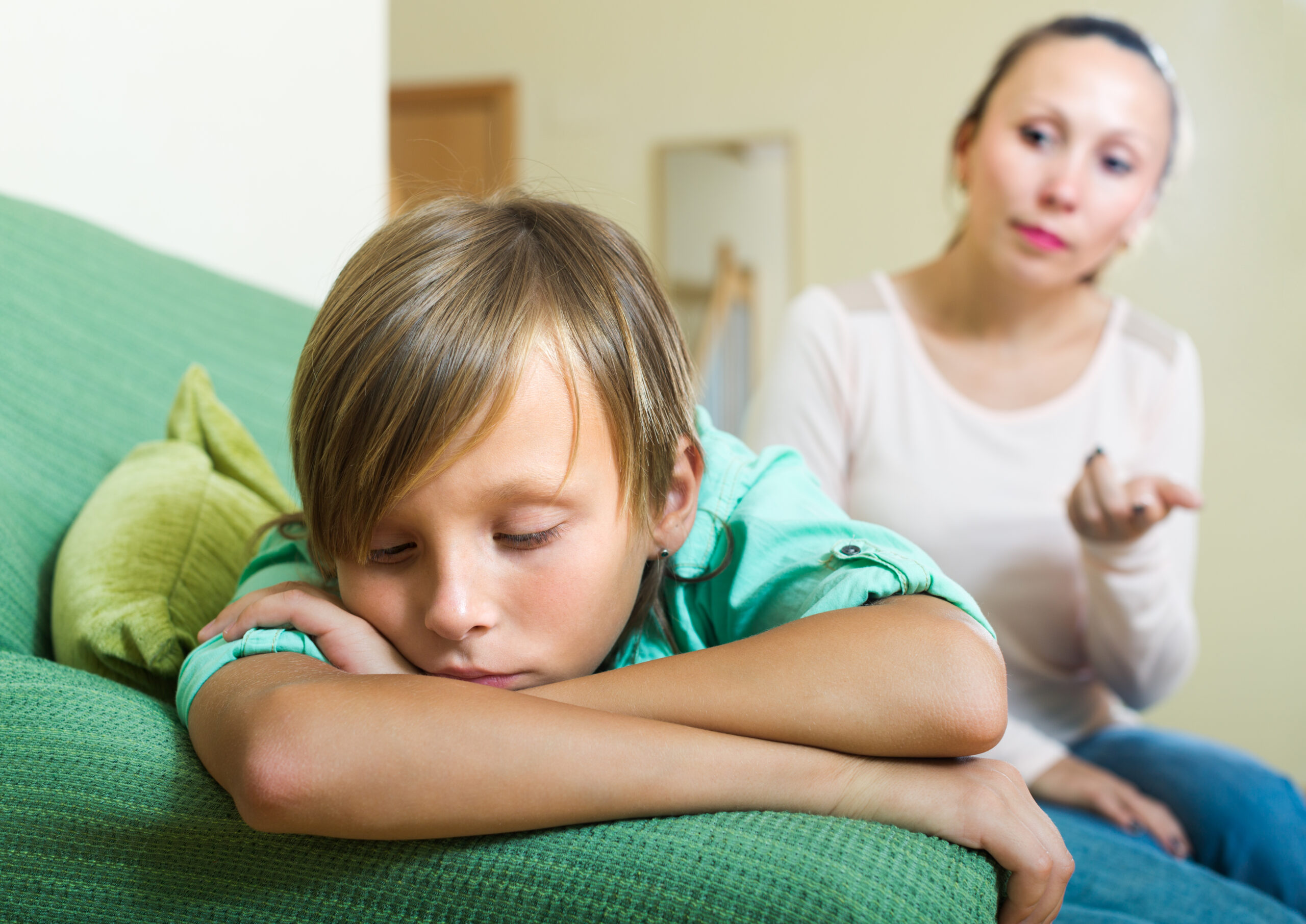 Teenager son sitting offended after conflict with mother at home